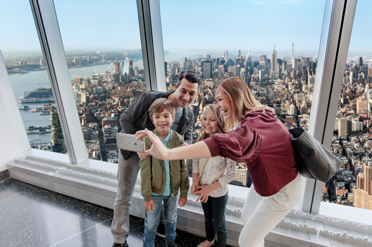 Inside the One World Observatory A family takes a selfie at One World Observatory with a view of the New York City skyline behind them